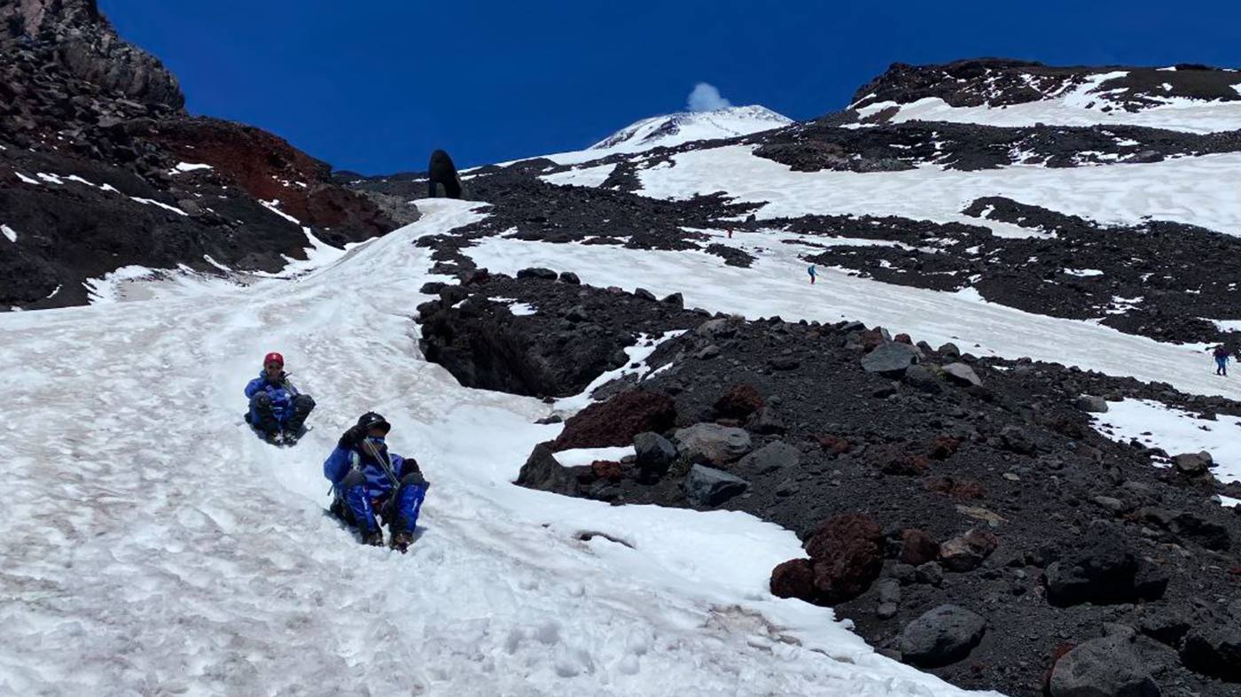 Wandelaars in de sneeuw op de flank van de Villarrica