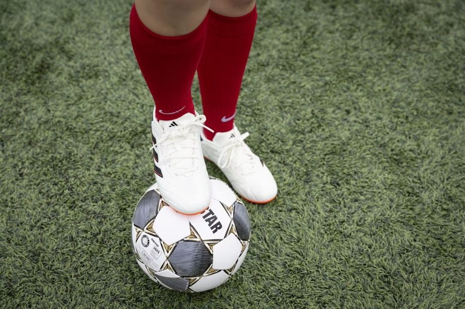 Voetbalschoenen en een bal op het kunstgras